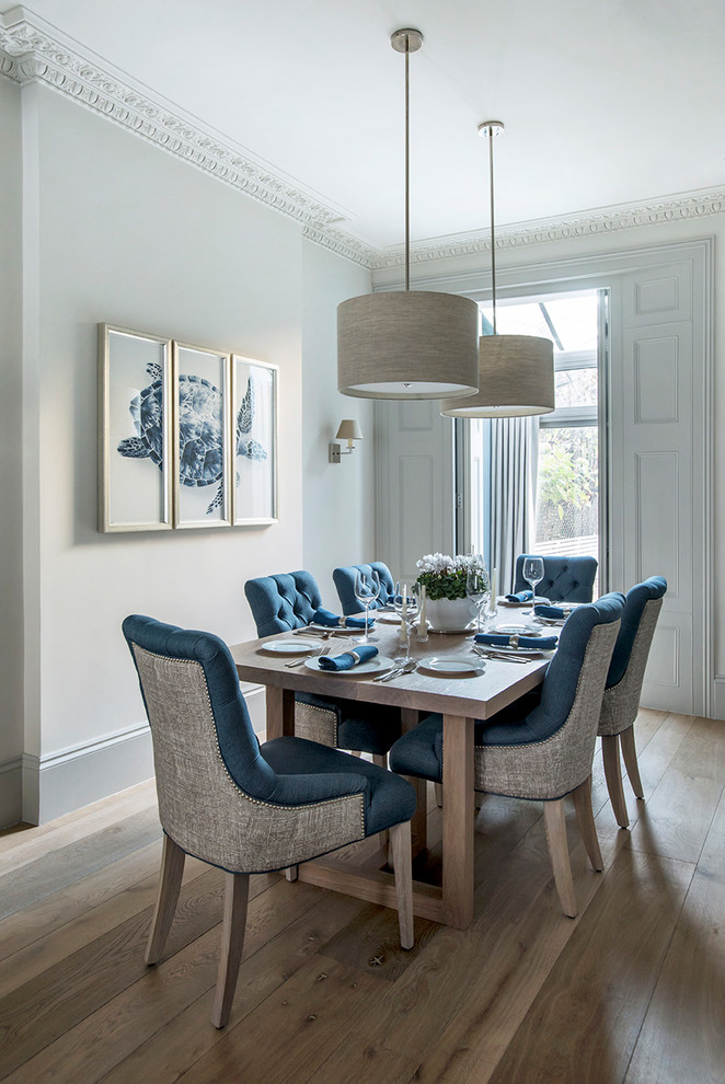 This is an example of a transitional dining room with grey walls, medium hardwood floors and brown floor.