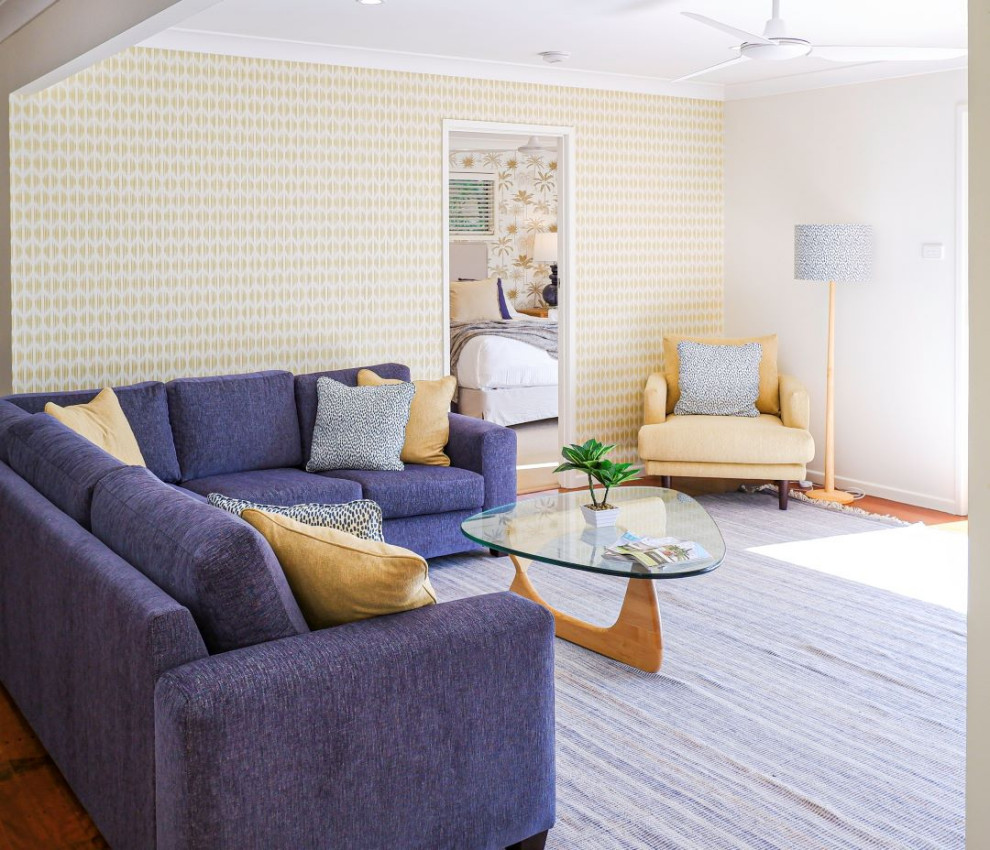 Свежая идея для дизайна: открытая гостиная комната среднего размера в стиле фьюжн с желтыми стенами, паркетным полом среднего тона и обоями на стенах - отличное фото интерьера