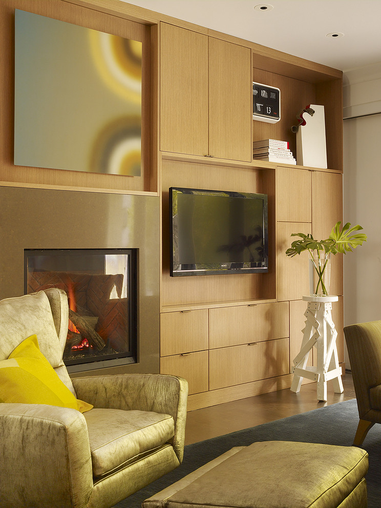 This is an example of a contemporary family room in San Francisco with a standard fireplace and a wall-mounted tv.