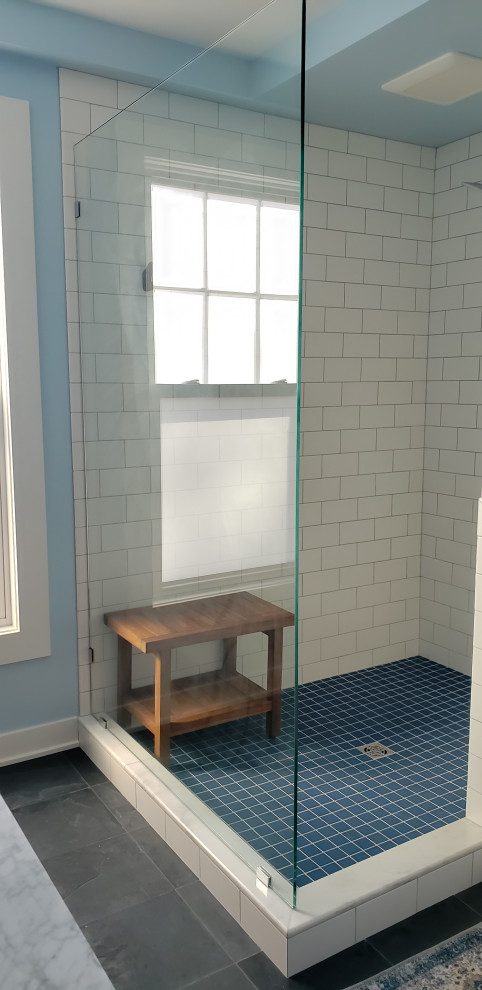 Design ideas for a mid-sized midcentury master bathroom in Minneapolis with flat-panel cabinets, medium wood cabinets, a drop-in tub, an open shower, a one-piece toilet, white tile, ceramic tile, blue walls, slate floors, an undermount sink, marble benchtops, black floor, an open shower, white benchtops, a double vanity and a freestanding vanity.
