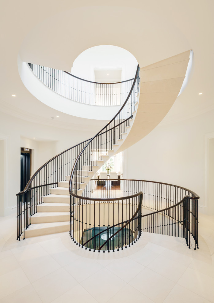 Inspiration for a contemporary limestone spiral staircase in Surrey with limestone risers and metal railing.