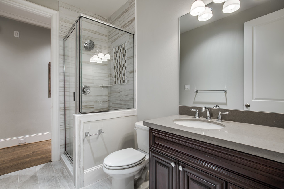 Large arts and crafts kids bathroom in Houston with shaker cabinets, brown cabinets, a corner shower, a two-piece toilet, grey walls, ceramic floors, an undermount sink, terrazzo benchtops, grey floor and a hinged shower door.