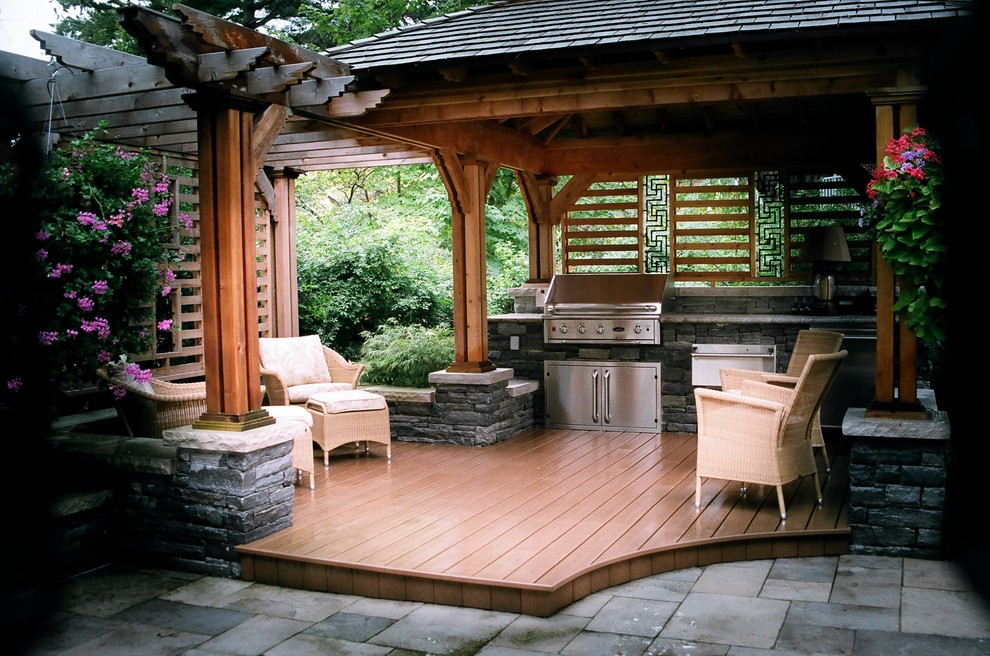 This is an example of an asian backyard patio in Toronto with an outdoor kitchen, decking and a pergola.
