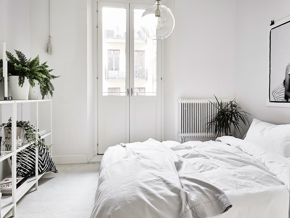This is an example of a scandinavian master bedroom in Gothenburg with white walls and no fireplace.