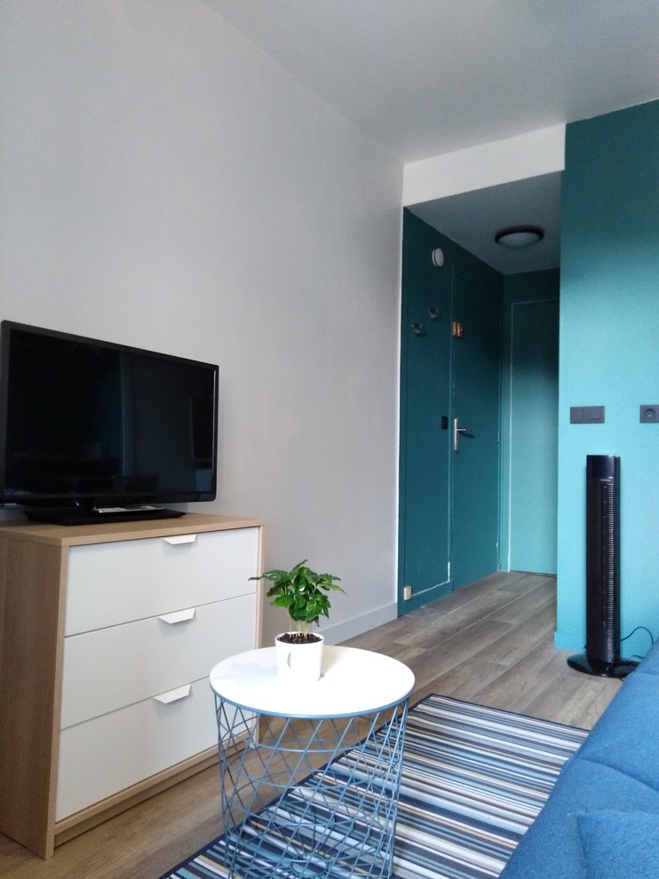 Cette photo montre un petit salon rétro ouvert avec parquet clair, un sol marron et un téléviseur indépendant.
