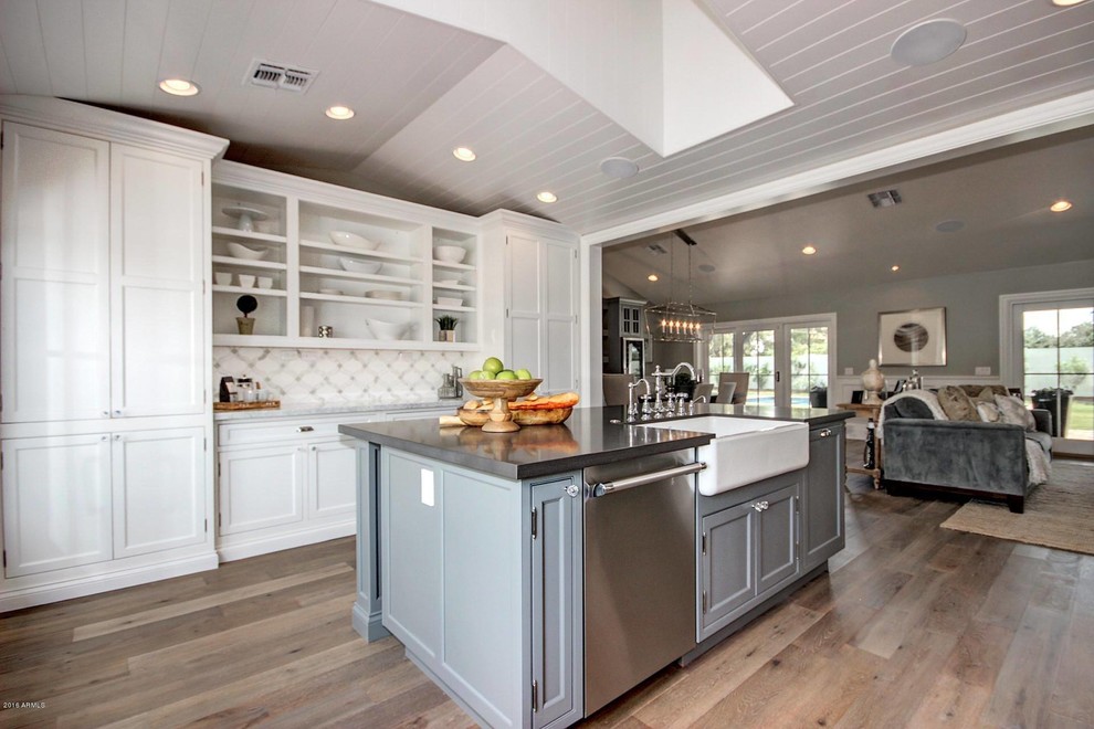 Eat-in kitchen - mid-sized transitional galley light wood floor eat-in kitchen idea in Phoenix with a farmhouse sink, recessed-panel cabinets, white cabinets, quartz countertops, multicolored backsplash, porcelain backsplash, stainless steel appliances and an island