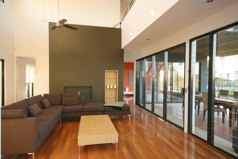 Mid-sized contemporary open concept living room in Sunshine Coast with grey walls and bamboo floors.