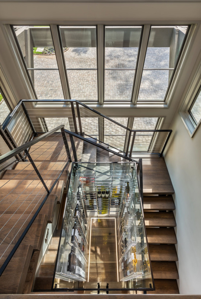 Пример оригинального дизайна: большая п-образная лестница в современном стиле с деревянными ступенями и металлическими перилами без подступенок