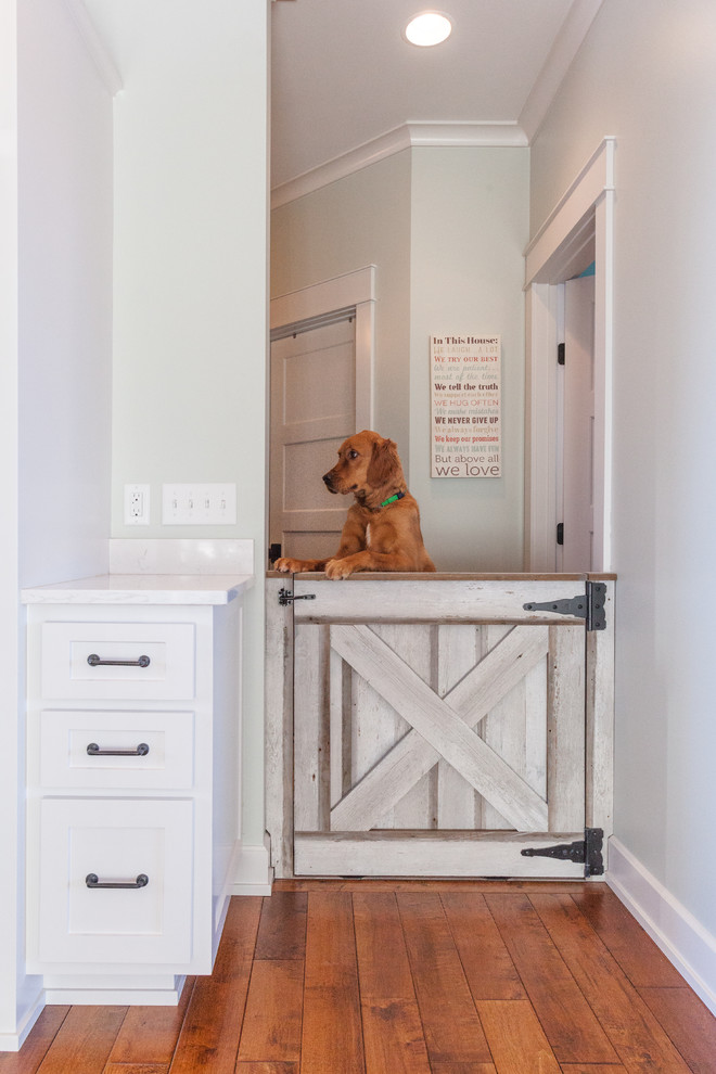 Inspiration for a traditional hallway in Minneapolis with white walls and dark hardwood floors.