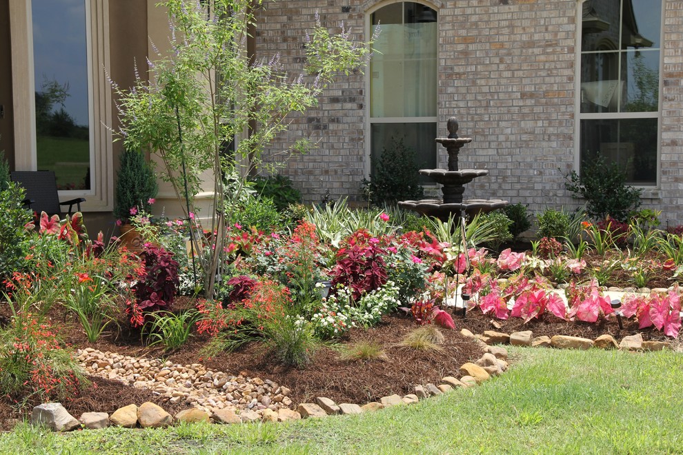 Photo of a mid-sized contemporary front yard full sun formal garden in New Orleans with a water feature and mulch.