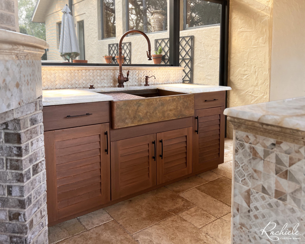 Inspiration for a large mediterranean kitchen remodel in Orlando with a farmhouse sink, medium tone wood cabinets, an island and beige countertops