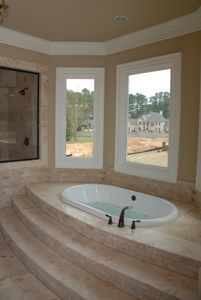 Photo of a large traditional master bathroom in Atlanta with furniture-like cabinets, dark wood cabinets, a drop-in tub, a corner shower, beige tile, limestone, yellow walls, limestone floors, an undermount sink, granite benchtops, beige floor, a hinged shower door and yellow benchtops.