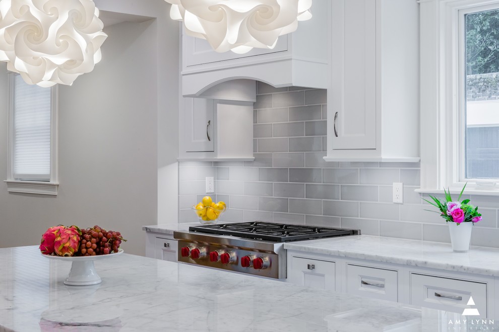 Mid-sized transitional l-shaped medium tone wood floor and red floor eat-in kitchen photo in Boston with an undermount sink, beaded inset cabinets, white cabinets, marble countertops, gray backsplash, porcelain backsplash, paneled appliances, an island and yellow countertops