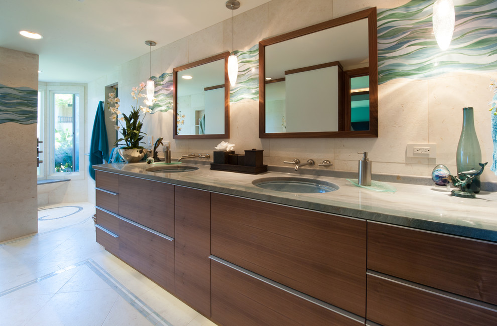 Inspiration for a tropical bathroom in Hawaii with flat-panel cabinets, medium wood cabinets, an open shower, a one-piece toilet, white tile, stone tile, beige walls, limestone floors, an undermount sink and quartzite benchtops.