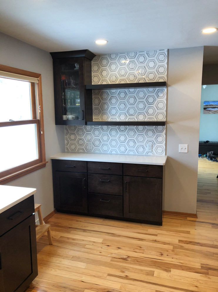 Eat-in kitchen - mid-sized transitional galley light wood floor and brown floor eat-in kitchen idea with an undermount sink, shaker cabinets, black cabinets, quartz countertops, gray backsplash, subway tile backsplash, stainless steel appliances, no island and white countertops