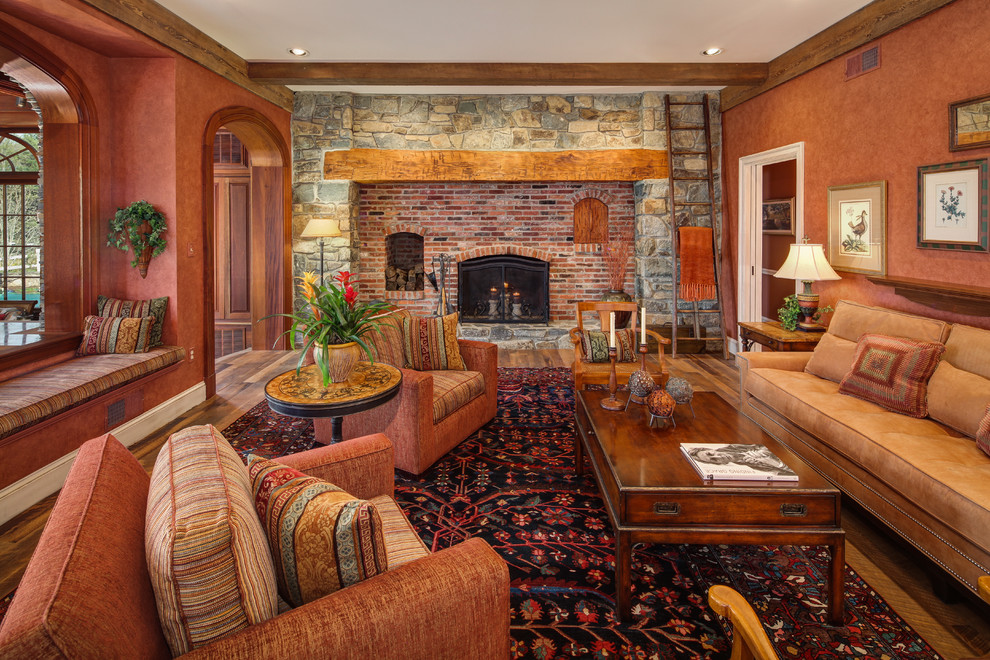 This is an example of a traditional family room in DC Metro with brown walls, medium hardwood floors, a standard fireplace and a brick fireplace surround.