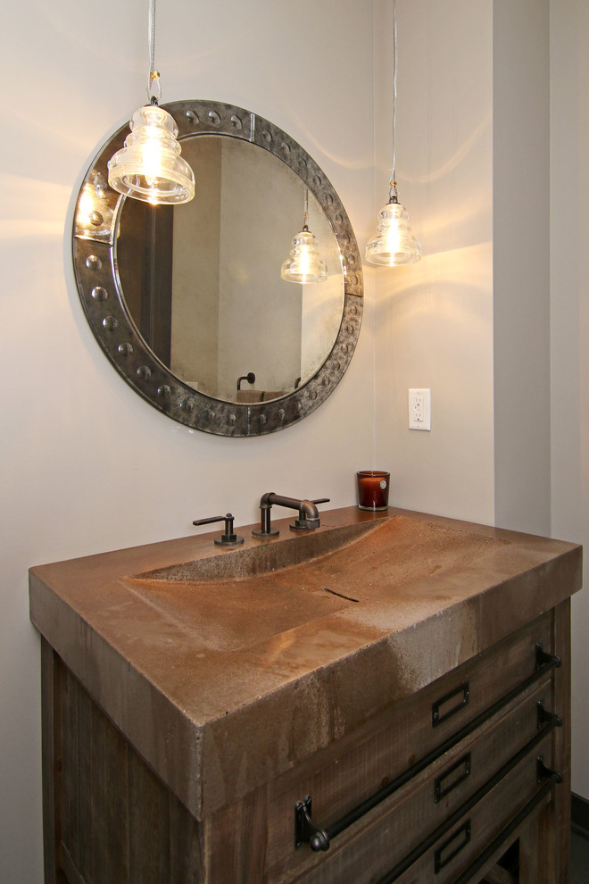 Design ideas for a mid-sized industrial powder room in Minneapolis with flat-panel cabinets, medium wood cabinets, grey walls, an integrated sink and concrete benchtops.
