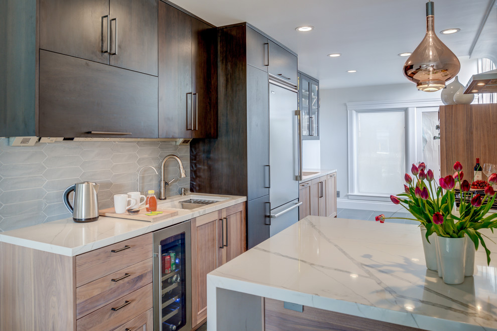 Photo of a large contemporary l-shaped eat-in kitchen in San Francisco with an undermount sink, shaker cabinets, medium wood cabinets, quartz benchtops, white splashback, stainless steel appliances and white benchtop.