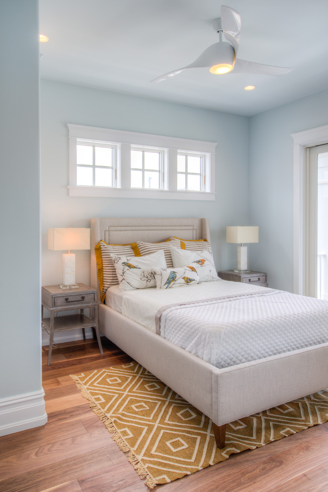 This is an example of a mid-sized transitional guest bedroom in Philadelphia with blue walls, medium hardwood floors, no fireplace and brown floor.