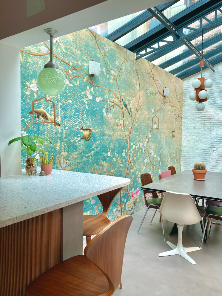 Large eclectic open plan dining in Paris with white walls, concrete floors, grey floor and brick walls.