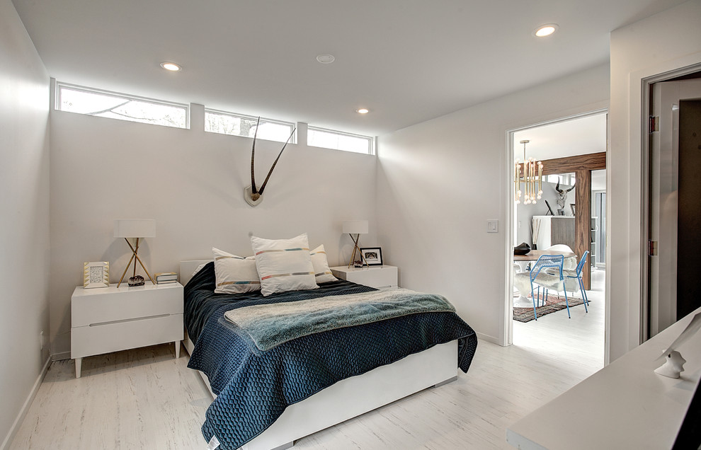 Design ideas for a midcentury master bedroom in Grand Rapids with white walls and light hardwood floors.
