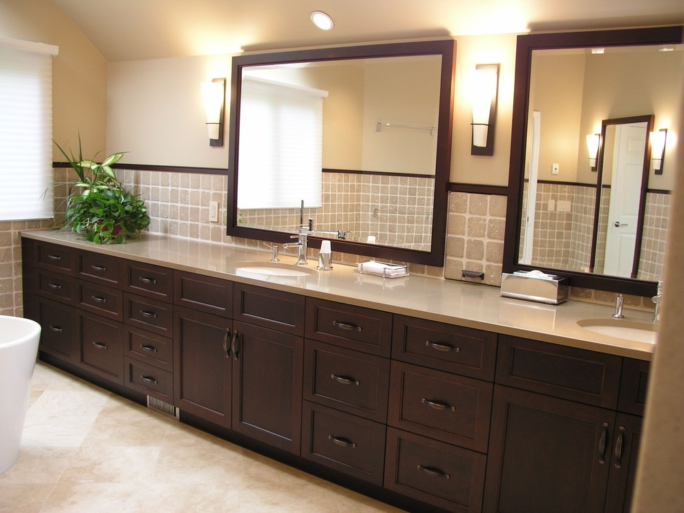 Contemporary bathroom in New York with an undermount sink, shaker cabinets, dark wood cabinets, a freestanding tub, beige tile and stone tile.