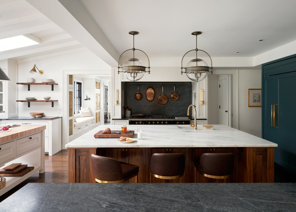 Inspiration for a large traditional eat-in kitchen in Other with an undermount sink, recessed-panel cabinets, dark wood cabinets, soapstone benchtops, black splashback, stone slab splashback, dark hardwood floors, multiple islands, brown floor and black benchtop.