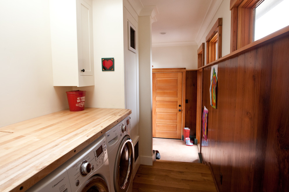 This is an example of a traditional laundry room in San Francisco with wood benchtops and beige benchtop.