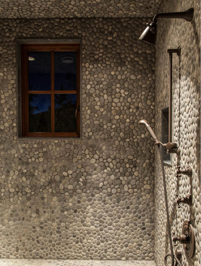 Inspiration for a huge rustic master beige tile and stone slab slate floor doorless shower remodel with a pedestal sink, distressed cabinets, wood countertops and beige walls