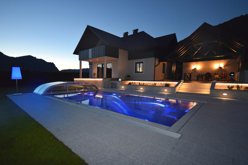 This is an example of an expansive contemporary side yard lap pool in Hamburg with tile.