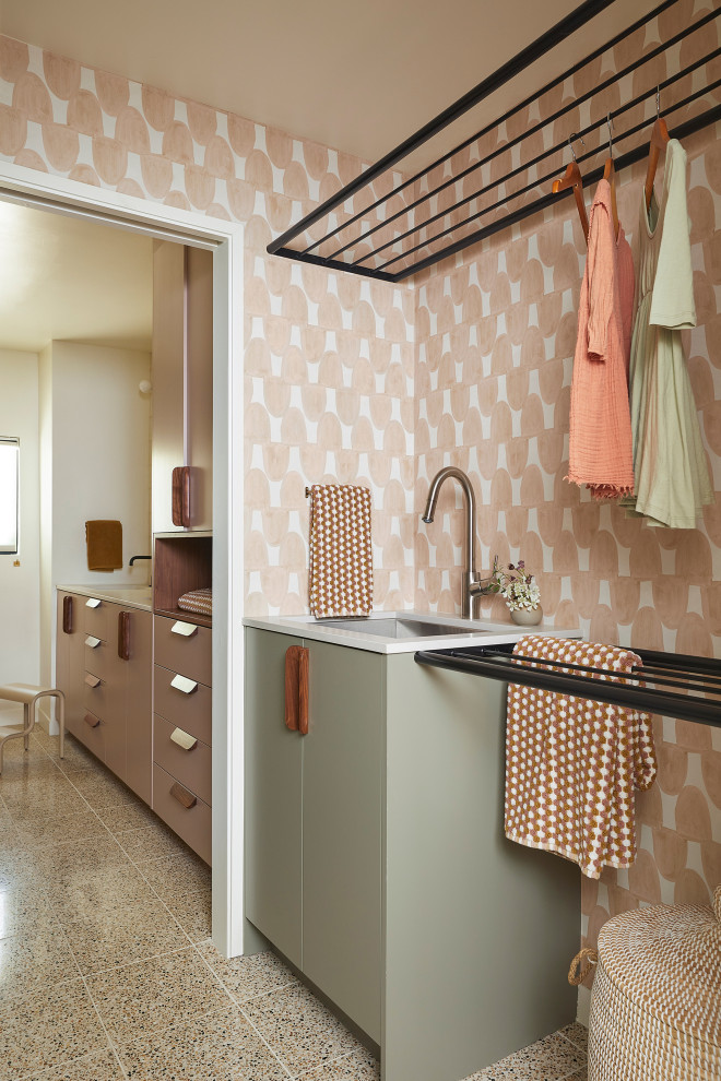 Inspiration for a small retro galley separated utility room in San Francisco with a submerged sink, flat-panel cabinets, green cabinets, engineered stone countertops, pink walls, concrete flooring, a side by side washer and dryer, brown floors, grey worktops and wallpapered walls.