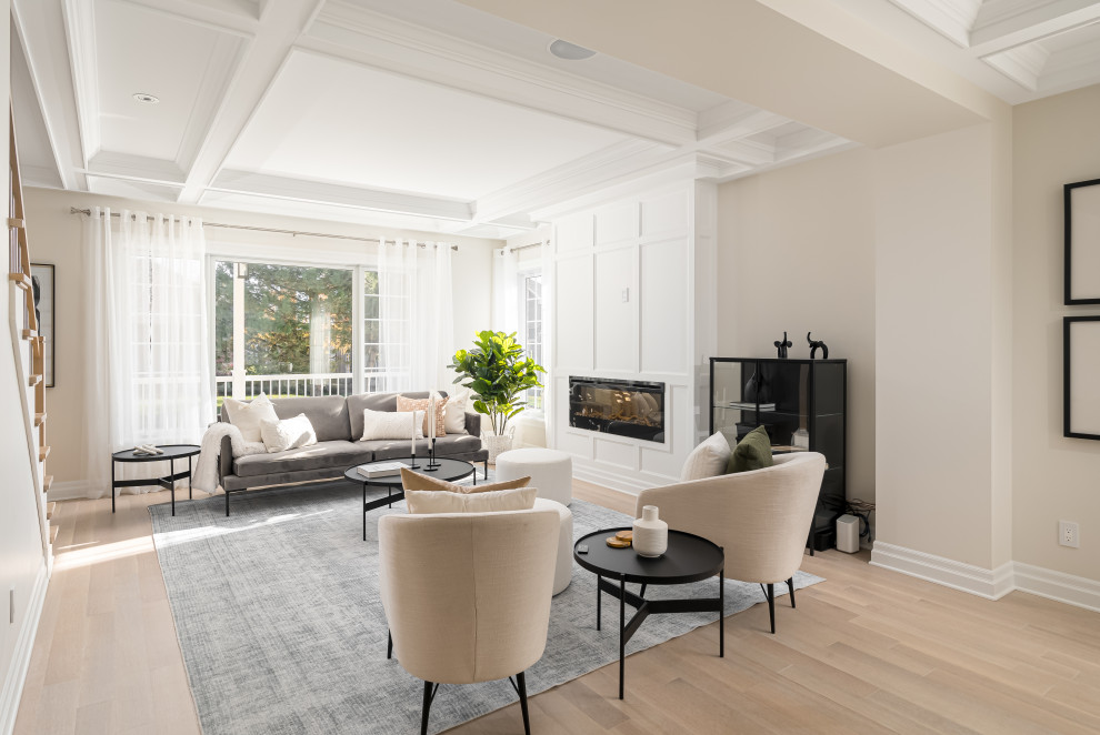Photo of a large contemporary formal open concept living room in Montreal with beige walls, light hardwood floors, a standard fireplace, a wall-mounted tv, brown floor and coffered.