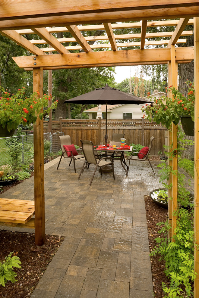 This is an example of a traditional side yard patio in Minneapolis with a pergola.
