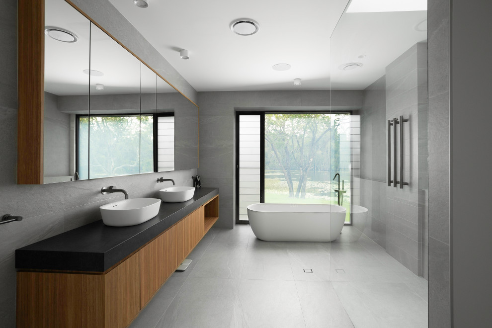 Источник вдохновения для домашнего уюта: главная ванная комната в стиле модернизм с фасадами цвета дерева среднего тона, отдельно стоящей ванной, открытым душем, тумбой под две раковины и подвесной тумбой
