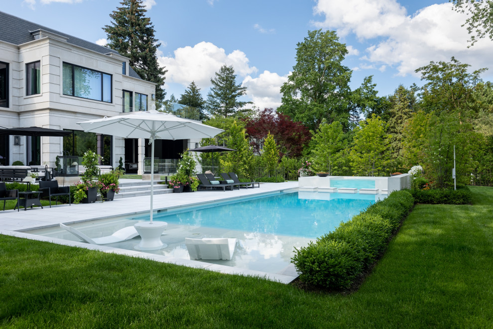 Свежая идея для дизайна: большой прямоугольный ландшафтный бассейн на заднем дворе в современном стиле с покрытием из каменной брусчатки - отличное фото интерьера