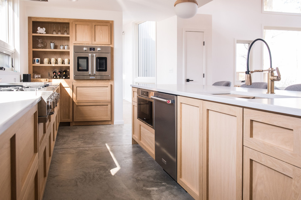Small modern u-shaped open plan kitchen in Other with an undermount sink, recessed-panel cabinets, light wood cabinets, quartz benchtops, stainless steel appliances, concrete floors, with island, grey floor and white benchtop.