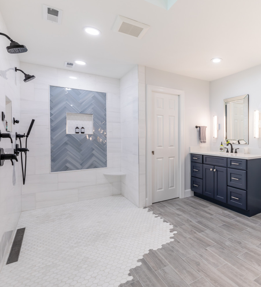 Bild på ett mellanstort funkis vit vitt en-suite badrum, med luckor med profilerade fronter, svarta skåp, ett fristående badkar, en dusch/badkar-kombination, en toalettstol med hel cisternkåpa, vit kakel, vita väggar, ett undermonterad handfat, grått golv och med dusch som är öppen