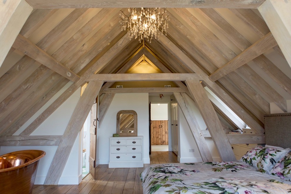 Inspiration for a country bedroom in Hampshire with beige walls, medium hardwood floors and brown floor.