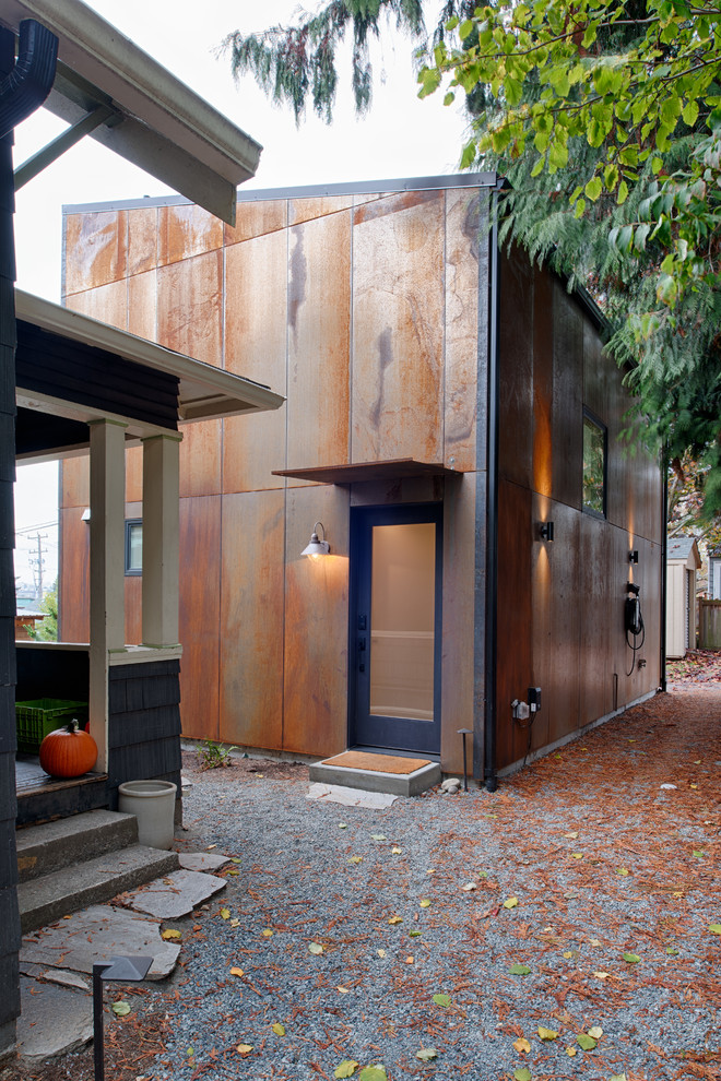 Small modern two-storey brown house exterior in Seattle with metal siding, a shed roof and a metal roof.