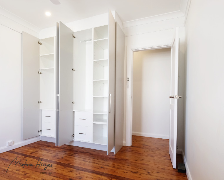 Example of a mid-sized trendy guest medium tone wood floor and brown floor bedroom design in Sydney with white walls