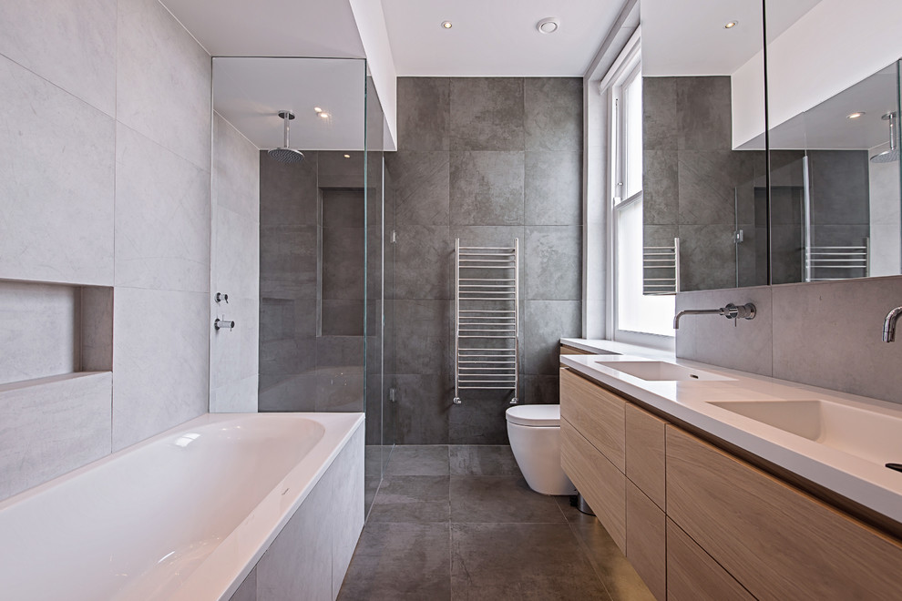 Contemporary bathroom in London with a corner shower and gray tile.