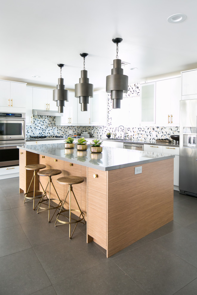 Inspiration for an expansive midcentury l-shaped kitchen in Orange County with an undermount sink, flat-panel cabinets, white cabinets, quartz benchtops, multi-coloured splashback, marble splashback, stainless steel appliances, ceramic floors, with island, grey floor and grey benchtop.