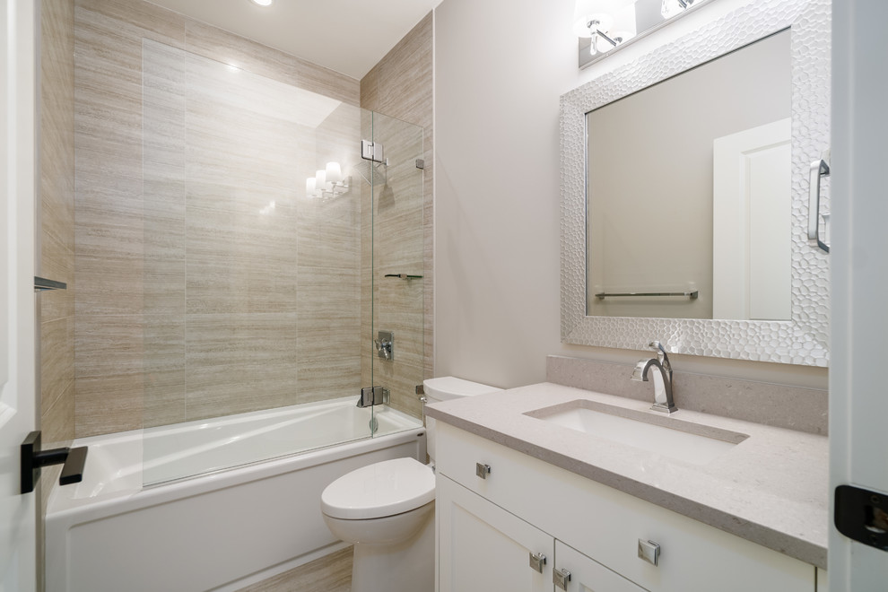 Design ideas for a mid-sized traditional kids bathroom in Vancouver with recessed-panel cabinets, white cabinets, an alcove tub, a shower/bathtub combo, a two-piece toilet, beige tile, porcelain tile, grey walls, porcelain floors, an undermount sink, engineered quartz benchtops, beige floor, a hinged shower door and grey benchtops.