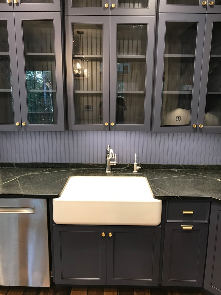 Design ideas for an eat-in kitchen in New York with a farmhouse sink, glass-front cabinets, purple cabinets, soapstone benchtops, timber splashback, stainless steel appliances and medium hardwood floors.