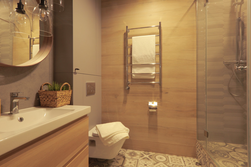 This is an example of a medium sized shower room bathroom in Moscow with flat-panel cabinets, beige cabinets, a corner shower, a wall mounted toilet, multi-coloured tiles, porcelain tiles, grey walls, porcelain flooring, a built-in sink, grey floors, a hinged door, a laundry area, a single sink and a floating vanity unit.