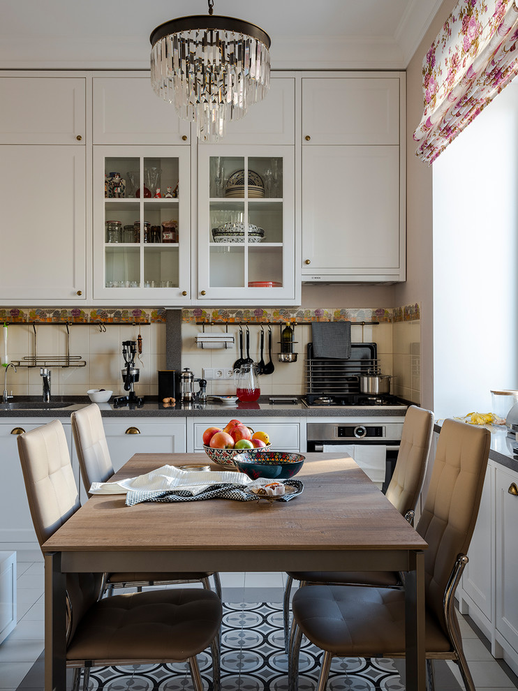 Inspiration for a small traditional single-wall eat-in kitchen in Moscow with an undermount sink, glass-front cabinets, white cabinets, quartz benchtops, beige splashback, ceramic splashback, stainless steel appliances, ceramic floors, grey floor and grey benchtop.
