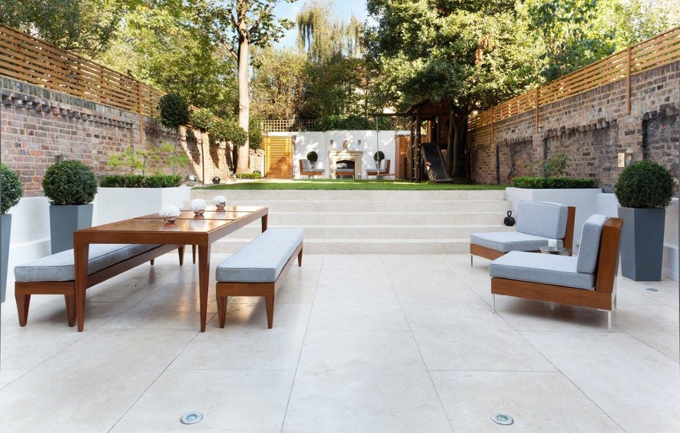 Inspiration for an expansive transitional backyard patio in London with tile and no cover.