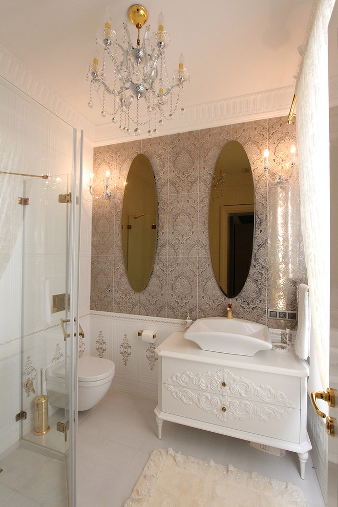 Inspiration for a traditional bathroom in London with white walls, porcelain floors, a vessel sink, white cabinets, a corner shower, a wall-mount toilet and white tile.