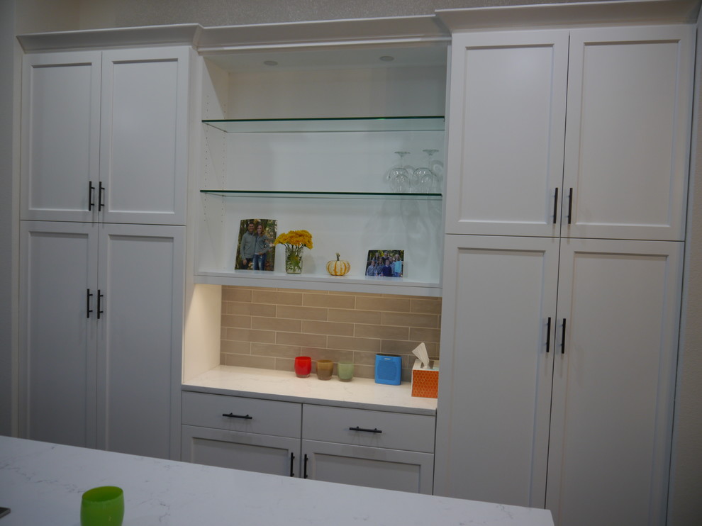 Inspiration for a large transitional dark wood floor and brown floor eat-in kitchen remodel in Seattle with a single-bowl sink, shaker cabinets, white cabinets, solid surface countertops, beige backsplash, ceramic backsplash, stainless steel appliances, an island and white countertops