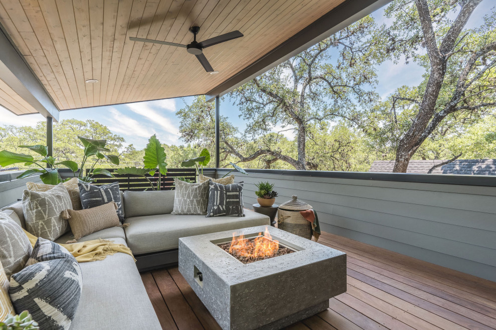 Immagine di un patio o portico minimalista di medie dimensioni con un focolare, pedane e un tetto a sbalzo